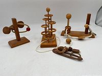 Overall view of four different wooden puzzles arranged on a white surface showing each puzzle's main structure and puzzle pieces.