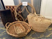 Photo showing decorative round wood and glass tray with rope handles, and four assorted baskets of various sizes and styles.