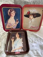 Front view of 3 Coca-Cola metal trays with vintage women artwork