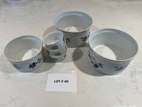 Set of three soufflé dishes and three ramekins on white stone surface.