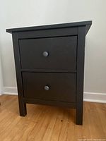 Front view of the Ikea Hemnes 2-drawer chest showing black-brown finish and two drawers with round knobs.