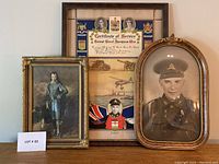 View of three framed items arranged together showing the certificate in the back, convex glass framed soldier portrait on the right, and a smaller reproduction portrait on the left.