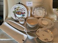 Full lot display including various plates, bowls, pudding basin, and marble cutting board