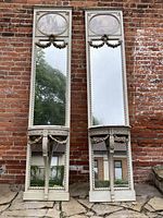 Front view of both full-height console mirrors against brick background