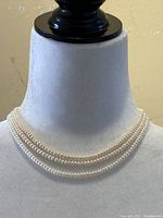 Three-strand pearl choker displayed on bust, front view