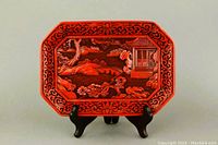 Front view of the octagonal red carved tray on display stand
