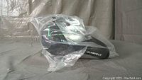 Plastic-wrapped green bike seat with black base showing GLAMVILLA branding and foam label.