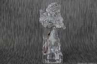 Clear crystal angel figurine playing violin on a dark textured background