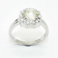 Front view of sterling silver ring with clear round center moissanite stone and smaller surrounding stones showing overall condition.