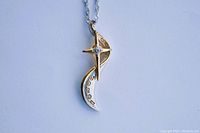 Front view of the pendant pendant showing two-tone design with crescent shape and small embedded stone