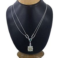 Front view of the necklace on display bust showing two moissanite stones and double chain design.