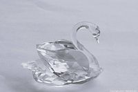 Swarovski crystal swan figurine photographed from side angle showing faceted body and curved neck, clear crystal material