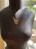 Brass double pendant necklace displayed on a mannequin bust showing length and how it hangs.
