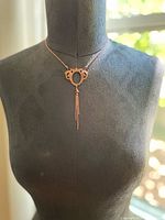 Full view of the antique copper necklace displayed on a mannequin showing the length and pendant placement.