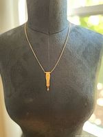 Full view of the brass cobra necklace displayed on a mannequin showing length and overall design