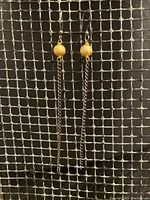 Full view of both earrings showing gold disco ball beads with oxidized metal chain tassels and earwires