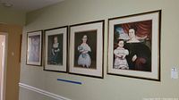 Four framed vintage-style portrait prints hung on a wall showing the overall set and arrangement, emphasizing the size and style of frames and prints.