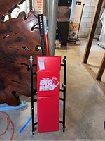 Full view of the red Torin Big Red padded mechanics creeper with black metal frame and wheels.