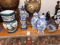 Overall view of lot, showing arrangement of urns, figurine, bowl, and vase on wood surface for scale and context