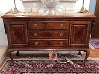 Front view of wooden buffet cabinet showing two cabinets and two drawers with round metal handles