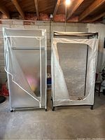 Two plastic enclosed clothes storage racks with translucent zippered covers on caster wheels.