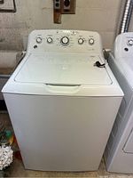 Front view of GE top load washer showing lid and control panel.