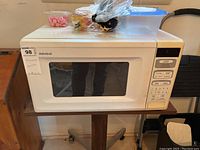 Front view of white Admiral microwave oven showing brand, keypad, and window on the door.