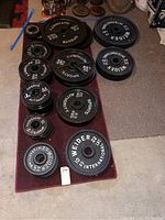 Overhead view of all weight plates on mat showing assortment of sizes and brands
