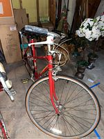 Full front-left view of red Schwinn bicycle showing drop handlebars, front tire, and frame with logos.
