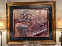 Full view of the framed print showing the ornate gold frame and an elegant still life scene including a piano, violin, and floral arrangement.