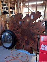 Front view of entire wood slab leaning against shelving in basement