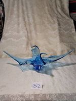 Front view of the Blue Chalet Lorraine blue art glass centerpiece showing its wide, irregular, flowing form with pointed extensions and glossy translucent finish.