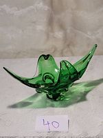 Front and side view of a green glass centre piece with stretched and flowing abstract design