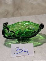 Side view of green Murano glass art fruit bowl with swirled pattern and pedestal base