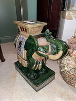 Full side view of the green glazed ceramic elephant side table with visible detailed painted accents and rectangular tabletop.