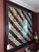Full view of framed log cabin quilt on wall