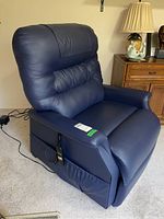 Front right angle view of blue leather recliner showing overall condition and remote cord
