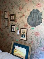 Full view of the wall showing multiple framed pettipoint needleworks arranged with ceramic plaque and framed print.