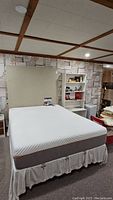 Full view of mattress on bed frame with headboard in basement room