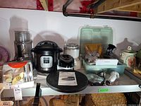 Overview of all small kitchen appliances on basement shelf, including food processor, Instant Pot, Presto oven, and more.