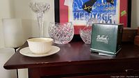 Overview photo showing Belleek cup and saucer, cut glass basket, crystal oval vase, and Waterford candle holders on a table.