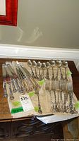 Overview of entire flatware set laid out on cloth