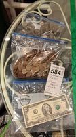 Overview of all items: $2 bill and two sealed bags of pennies and one of nickels