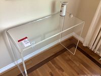 Full view of the transparent acrylic desk showing its rectangular shape and rounded edges.