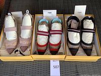 Three pairs of Fendi slingback pumps in open yellow Fendi boxes, each stuffed with paper