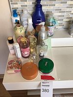 Full array of fragrance and skincare products on a white countertop, showcasing Michael Kors, Jimmy Choo, Chanel No 5, Yves Saint Laurent, Christian Dior, and others.