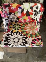 Full front view of chair showing floral upholstery and acrylic legs
