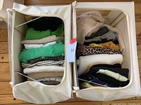 Overhead view of two storage bins filled with folded ladies tops and blouses in various colors and patterns.