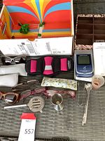 Lot overview showing eyeglasses, bar tools, organizer, calculator, and adapter on a table