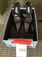 Pair of Prada black patent leather slingback pumps displayed in original box